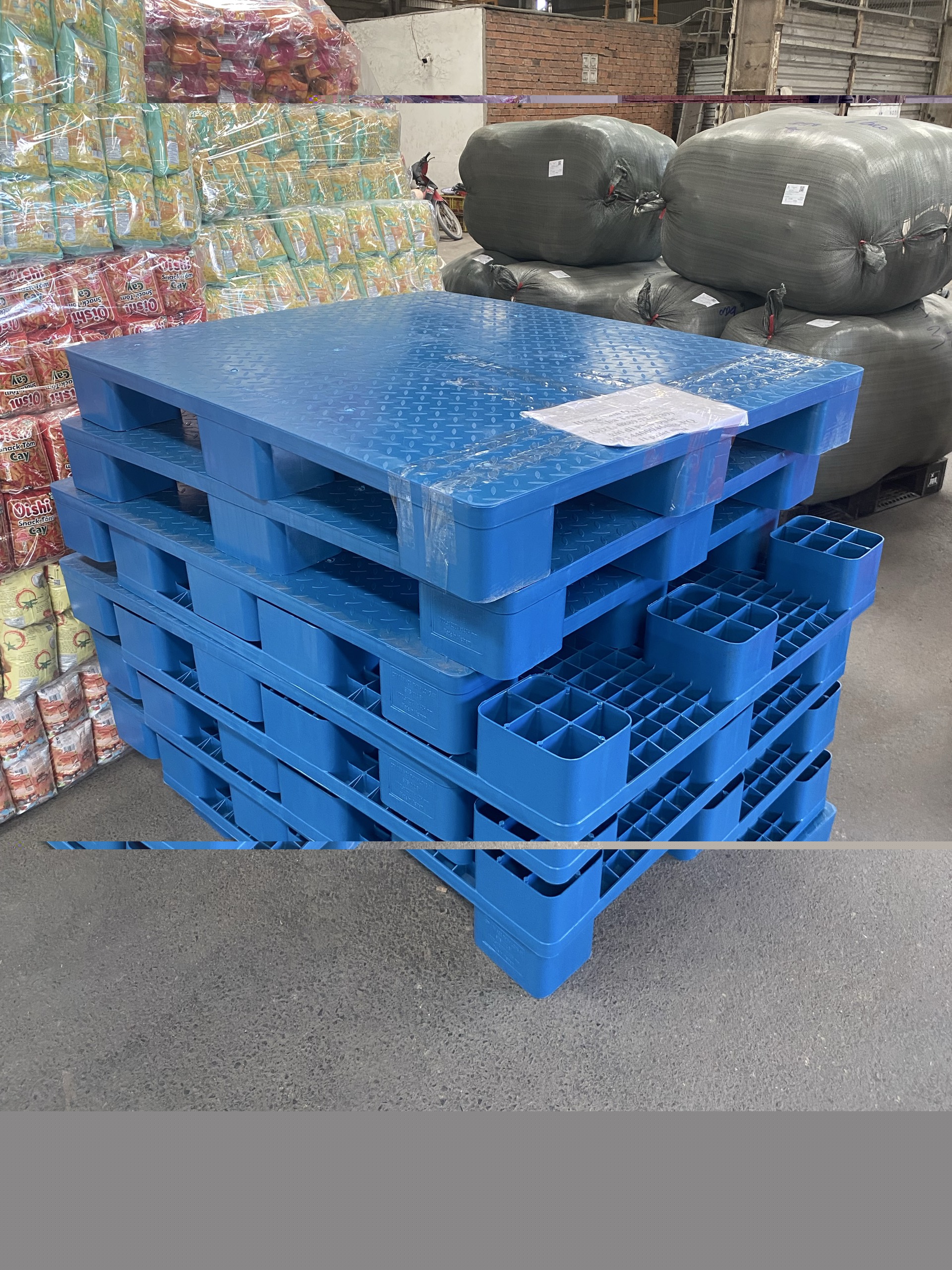 Pallet nhựa 1200x1000x140mm 9 chân màu xanh trong kho hàng