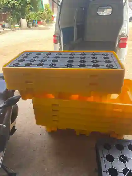Pallet nhựa chống tràn dầu màu vàng mặt lưới đen chuẩn bị giao hàng